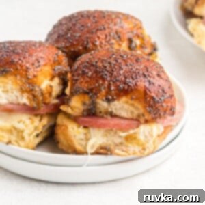 Effortless Easter with Your Air Fryer 18 Close up photo of golden small roll with ham and swiss cheese inside, glazed with a poppyseed glaze.