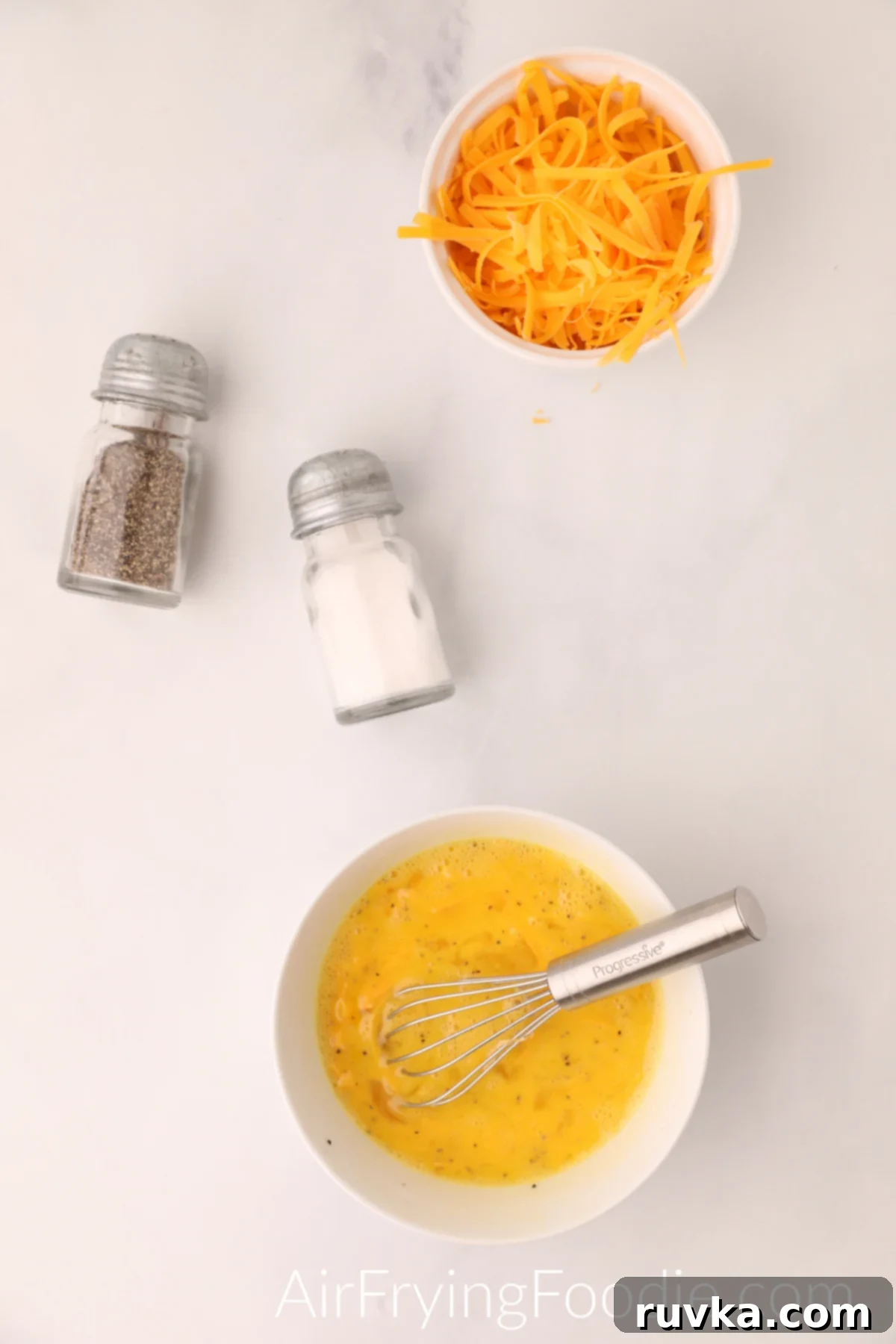 Fluffy Air Fryer Scrambled Eggs 4 Eggs whisked together in a bowl.