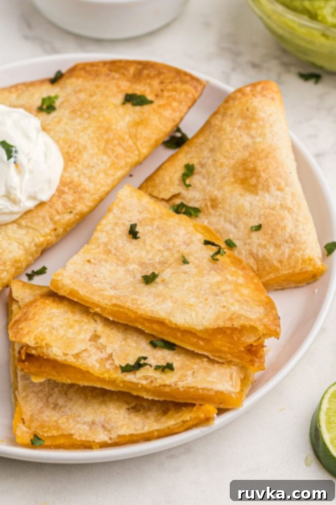 Crispy Air Fryer Quesadillas 8 Golden crispy air fryer quesadillas filled with deliciously melted cheese, garnished with fresh chopped cilantro and perfectly served with a side of creamy sour cream.