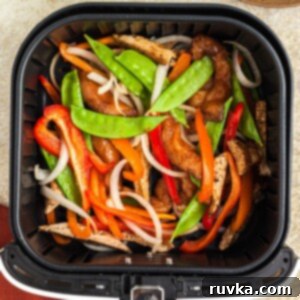 Crispy Air Fryer Stir-Fry 9 Juicy chicken and stir fry veggies in a an air fryer basket after being cooked