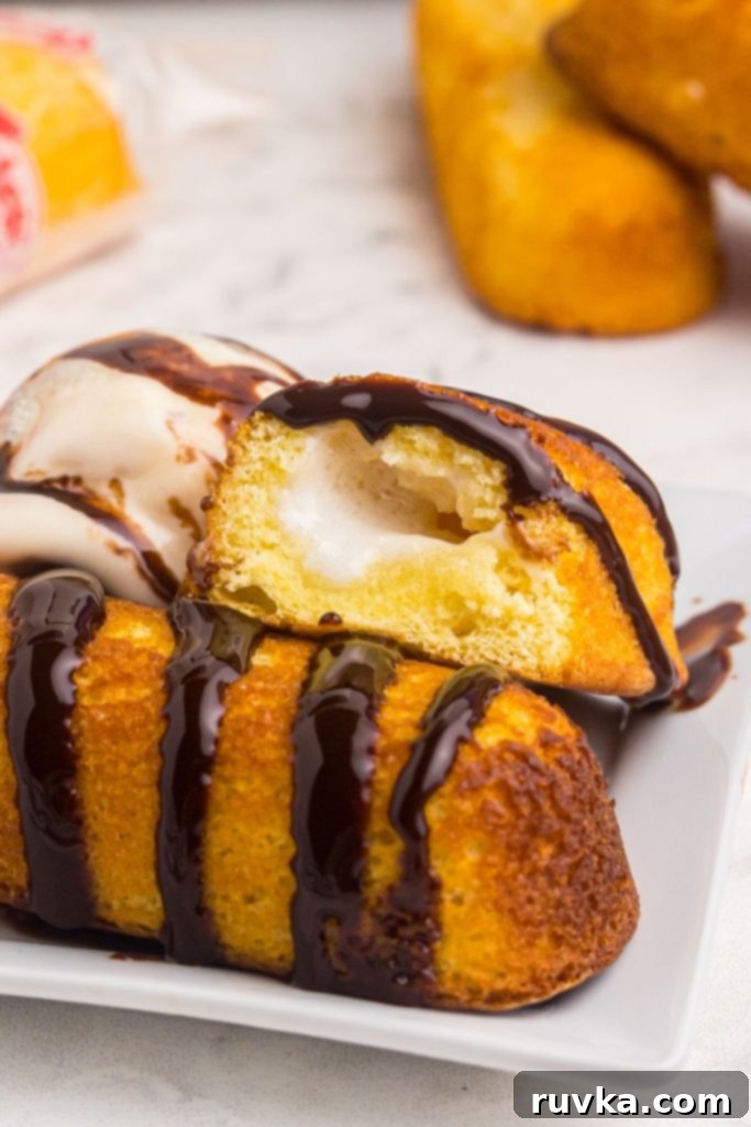 Warm Golden Air Fryer Twinkies 7 Platter of golden crispy Air Fryer Twinkies, elegantly drizzled with chocolate sauce and accompanied by a refreshing scoop of ice cream.