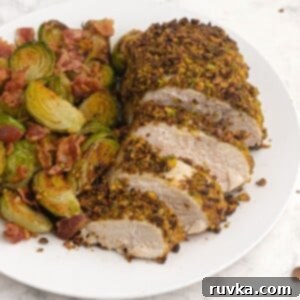 Crispy Pistachio Air Fryer Chicken 9 Cooked and sliced pistachio crusted chicken served with brussel sprouts on a white plate