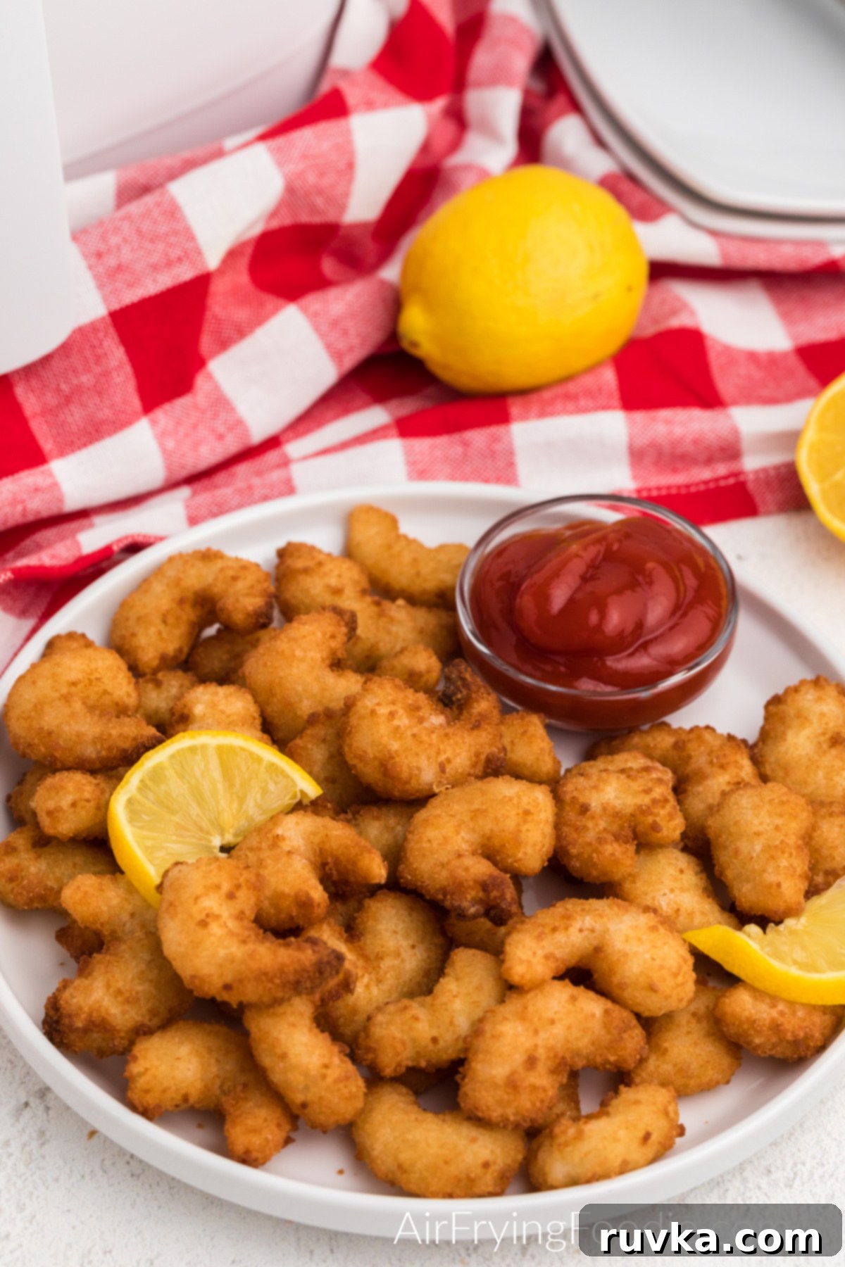 Crispy Frozen Popcorn Shrimp in Air Fryer 2 Frozen popcorn shrimp air fried to a crispy golden brown and served on a plate.