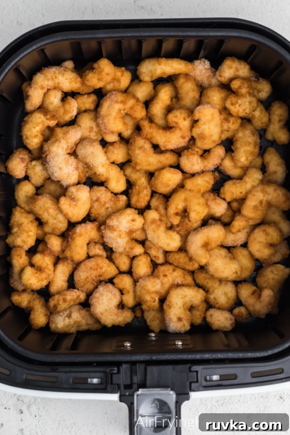 Crispy Frozen Popcorn Shrimp in Air Fryer 5 Frozen popcorn shrimp in air fryer basket, ready to be air fried.