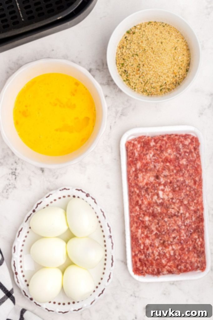 The Best Air Fryer Scotch Eggs 4 Ingredients measured and on a marble table for Scotch eggs.