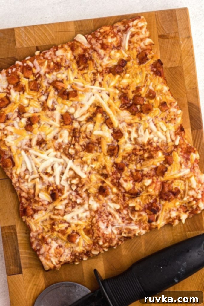 Crispy Air Fryer Tostino's Pizza 2 Golden crispy pizza on a cutting board with a pizza cutter on the board