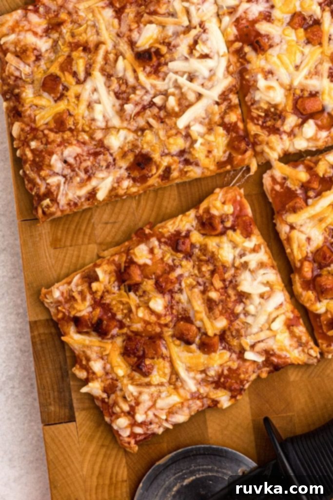Crispy Air Fryer Tostino's Pizza 3 Sliced pizza on a wooden cutting board with a pizza cutter