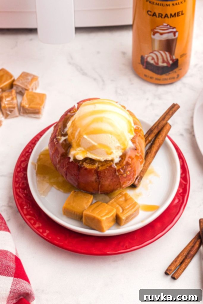 Air Fryer Blooming Apple Bliss 2 Juicy sliced apples coated with caramel sauce and topped with vanilla ice cream on a small white plate, ready to be enjoyed.