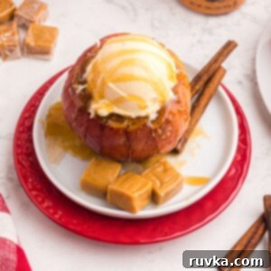 Air Fryer Blooming Apple Bliss 13 Vanilla ice cream on top of a blooming apple, with melted caramel and extra caramel squares on a white plate.