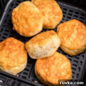 Fluffy Air Fryer Biscuits 7 Golden fluffy biscuits stacked in the air fryer basket.