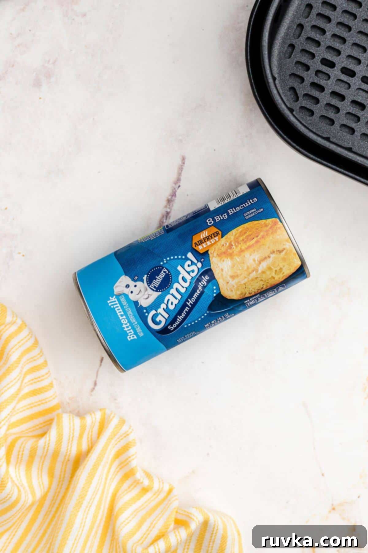 Fluffy Air Fryer Biscuits 3 Can of grands biscuits on marble table in front of the air fryer basket.