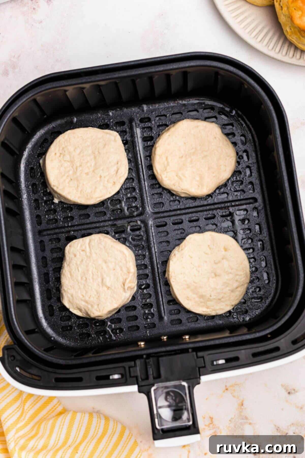 Fluffy Air Fryer Biscuits 4 Uncooked biscuit dough in the air fryer basket.