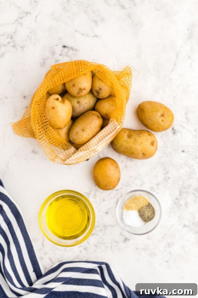Air Fryer Crispy Smashed Potatoes 3 Ingredients needed to make smashed potatoes in the air fryer, including baby gold potatoes, olive oil, and seasonings.
