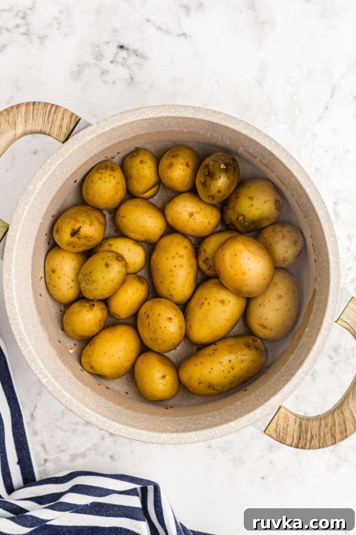 Air Fryer Crispy Smashed Potatoes 4 Small potatoes boiling in water in a saucepan, ready for smashing.