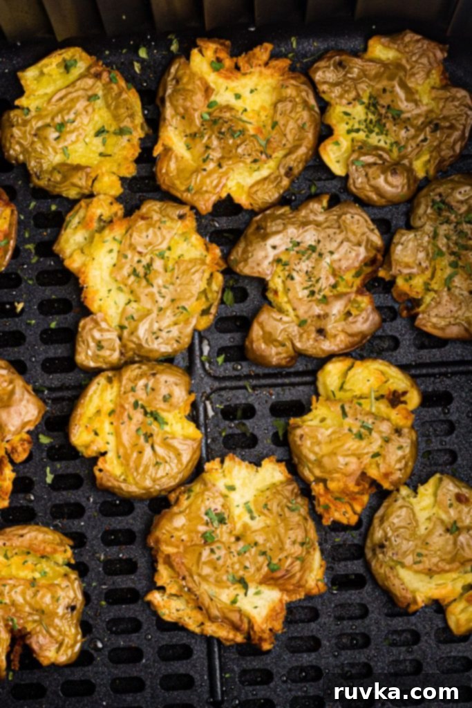 Air Fryer Crispy Smashed Potatoes 8 Golden smashed potatoes in the air fryer basket, perfectly cooked and ready to be served.