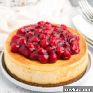 Perfect Air Fryer Cheesecake 10 Classic Air Fryer cheesecake with a glossy cherry topping, ready to be served.