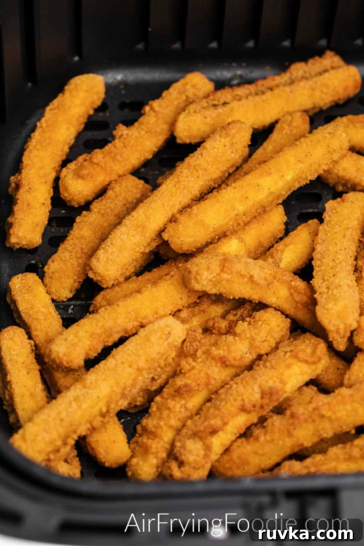 Crispy golden brown chicken fries cooked to perfection in an air fryer basket, ready to be served.