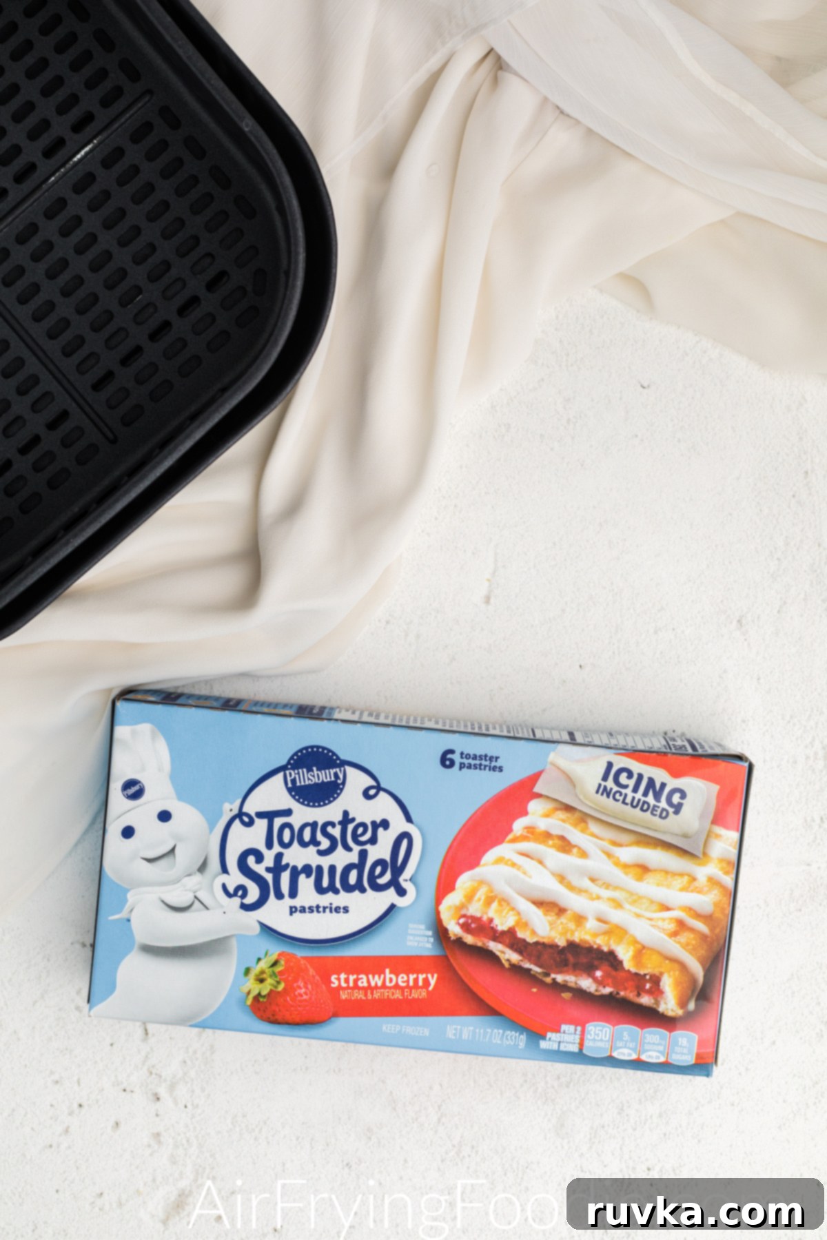 Flaky Air Fryer Strudel Bliss 4 Air fryer basket and Pillsbury toaster strudel in a box, ready to cook.