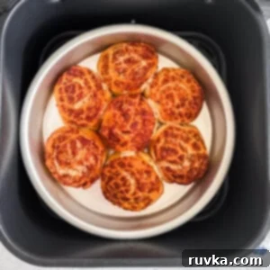 Easy Air Fryer Breakfasts 13 Warm, glazed cinnamon rolls in the air fryer basket, ready to be topped and served.