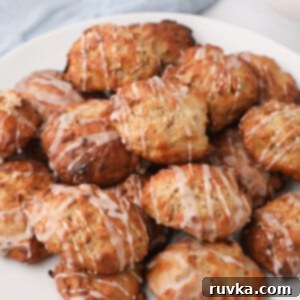 Easy Air Fryer Breakfasts 18 A plate brimming with delicious air fryer apple fritters, generously topped with a sweet glaze, served on a pristine white plate.