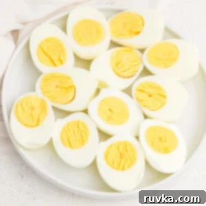 Easy Air Fryer Breakfasts 6 A plate full of air fried hard boiled eggs, cut in half, showcasing their perfectly cooked yolks.