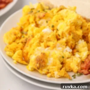 Easy Air Fryer Breakfasts 7 Fluffy scrambled eggs, freshly made in the air fryer, served on a white plate and ready to eat.