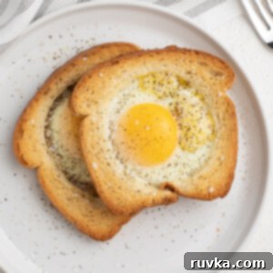 Easy Air Fryer Breakfasts 9 A perfectly cooked Air Fryer Eggs in a Basket, seasoned with salt and pepper, served on a white plate.