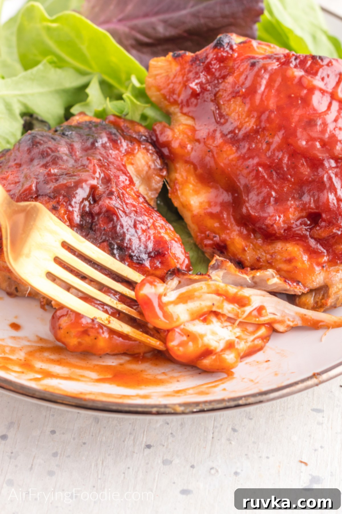 Perfect Air Fryer BBQ Chicken Thighs 5 A bit of bbq chicken thigh on a fork, ready to eat.