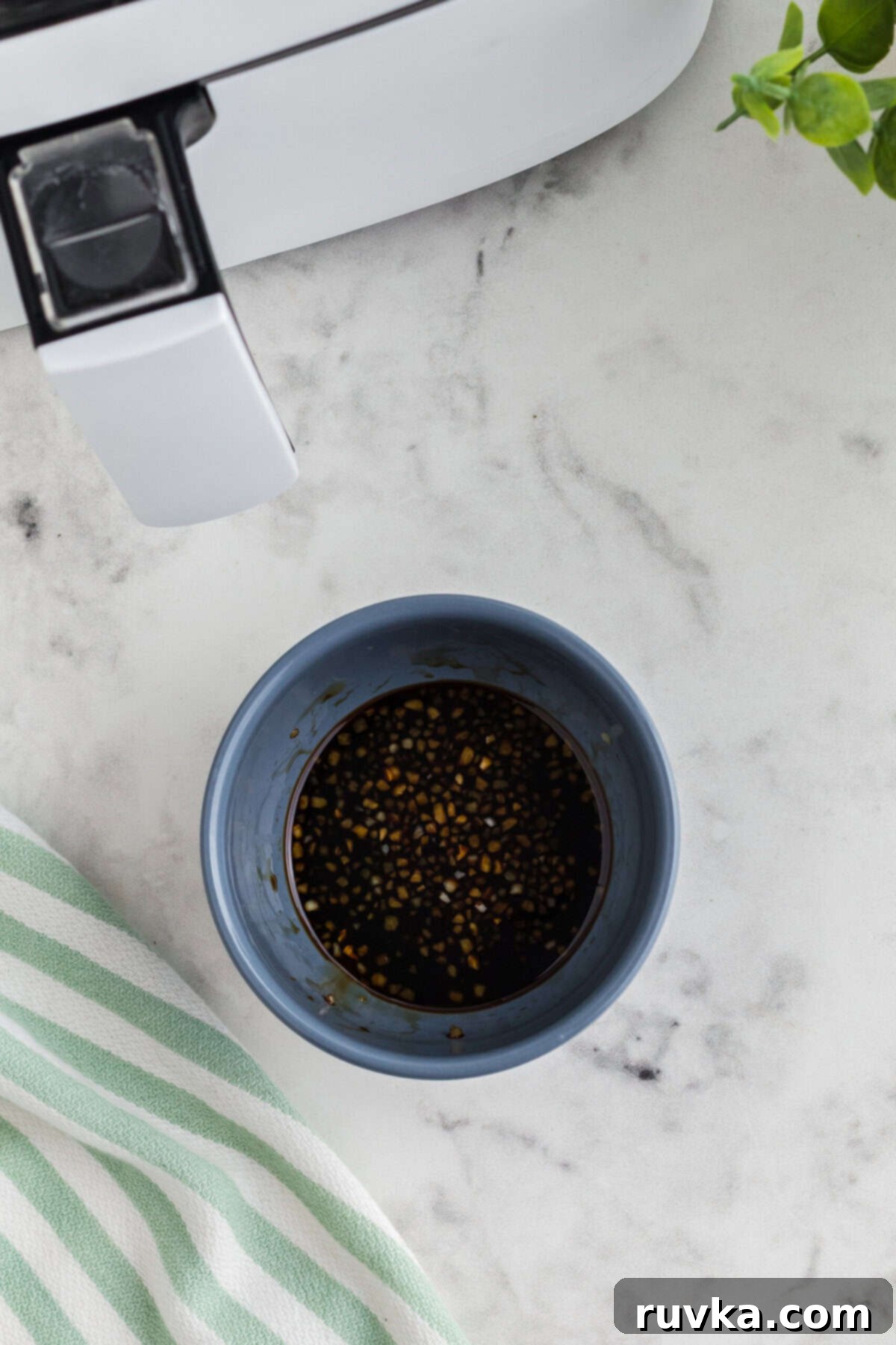 Crispy Air Fried Honey Garlic Chicken Strips 9 A small bowl containing mixed honey, soy sauce, and minced garlic.