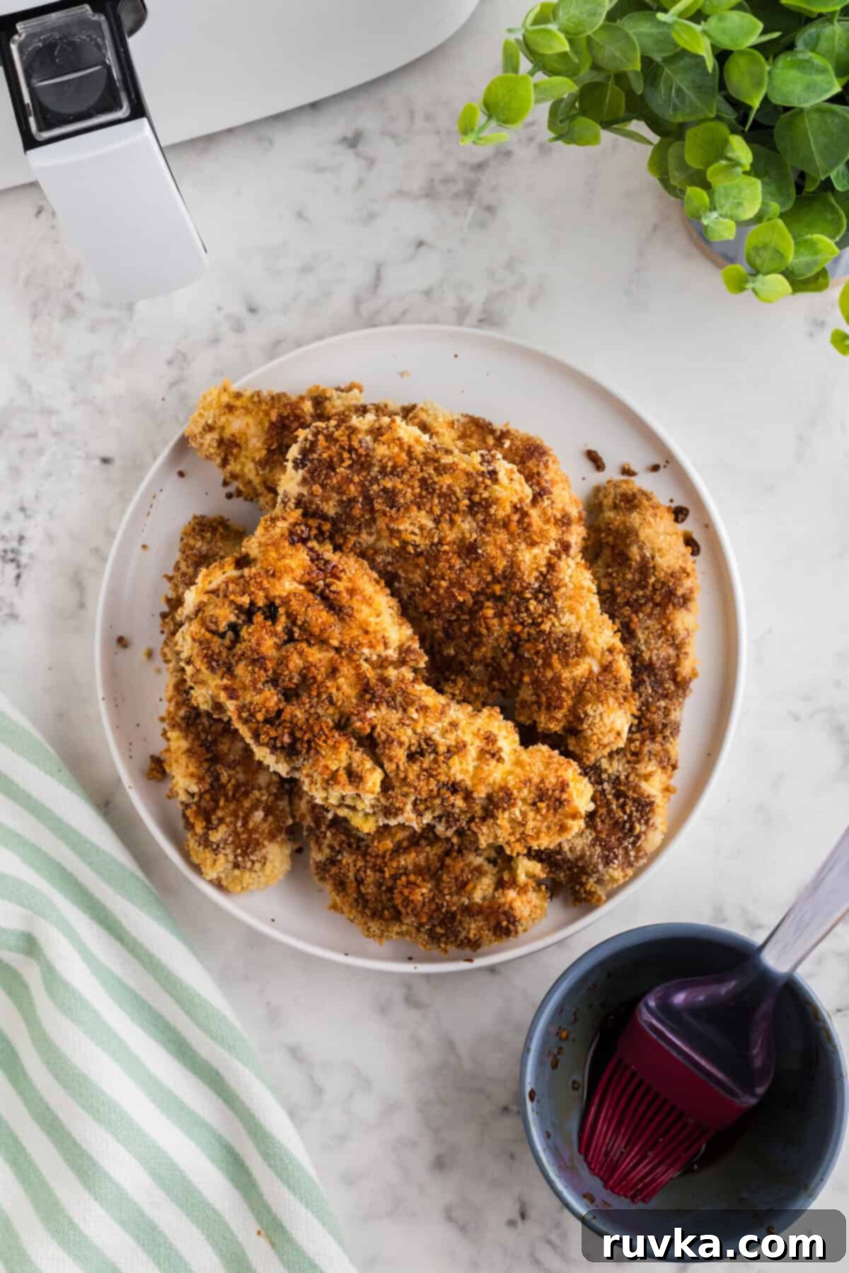 Crispy Air Fried Honey Garlic Chicken Strips 10 Cooked Air Fryer Honey Garlic Chicken Tenders being drizzled with honey garlic sauce.