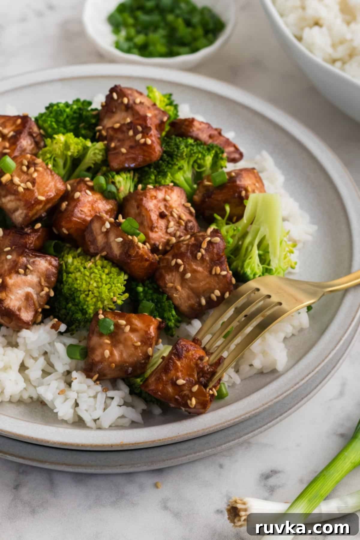 A vibrant close-up of Air Fryer Teriyaki Salmon Bites, expertly glazed and garnished with sesame seeds and green onions, ready to be enjoyed.