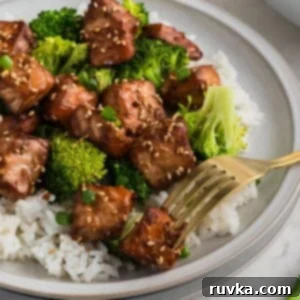 A delicious serving of Air Fryer Teriyaki Salmon Bites with a garnish of green onions and sesame seeds.