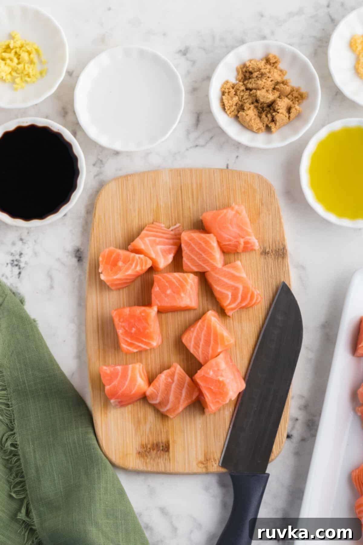 Step 1: Raw salmon fillets being patted dry with a paper towel on a cutting board, ready for cutting.