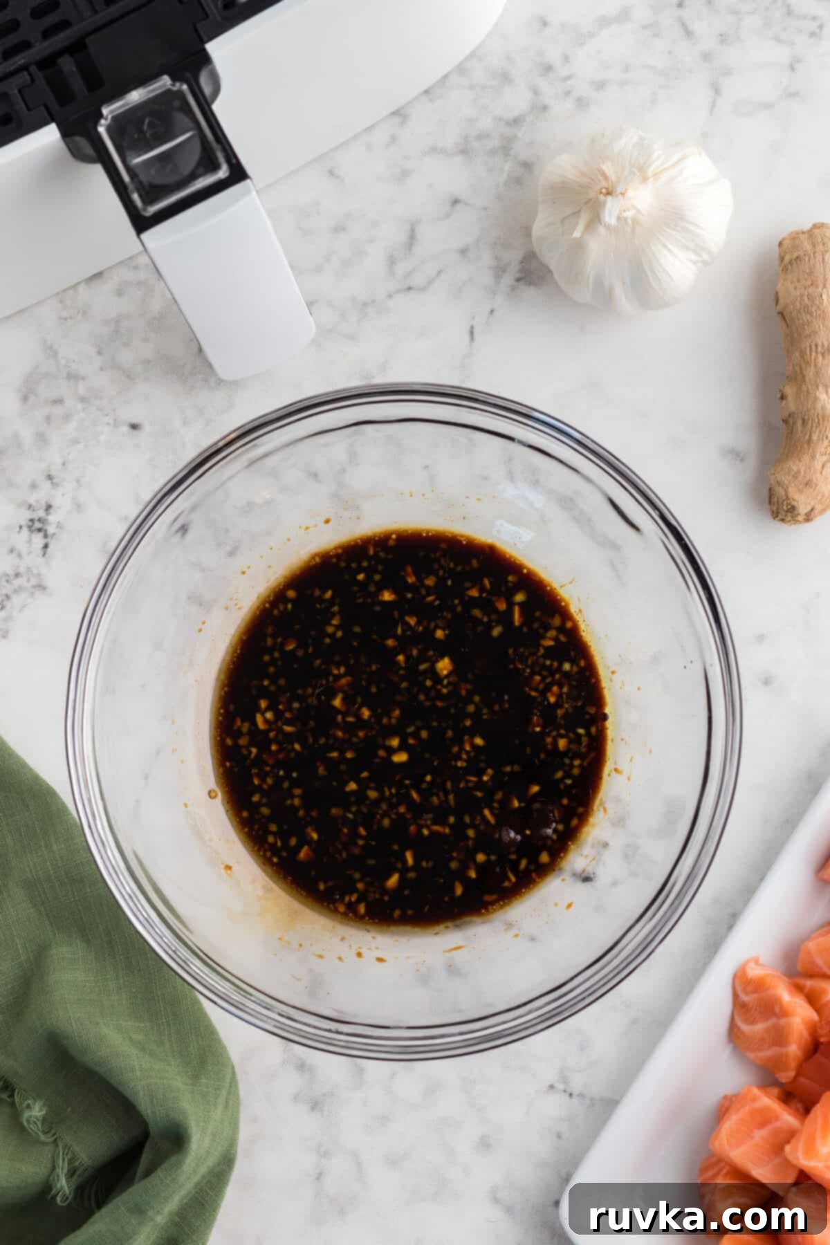 Step 2: Ingredients for the teriyaki marinade, including soy sauce, olive oil, water, brown sugar, minced garlic, and grated ginger, being combined in a medium bowl using a whisk.