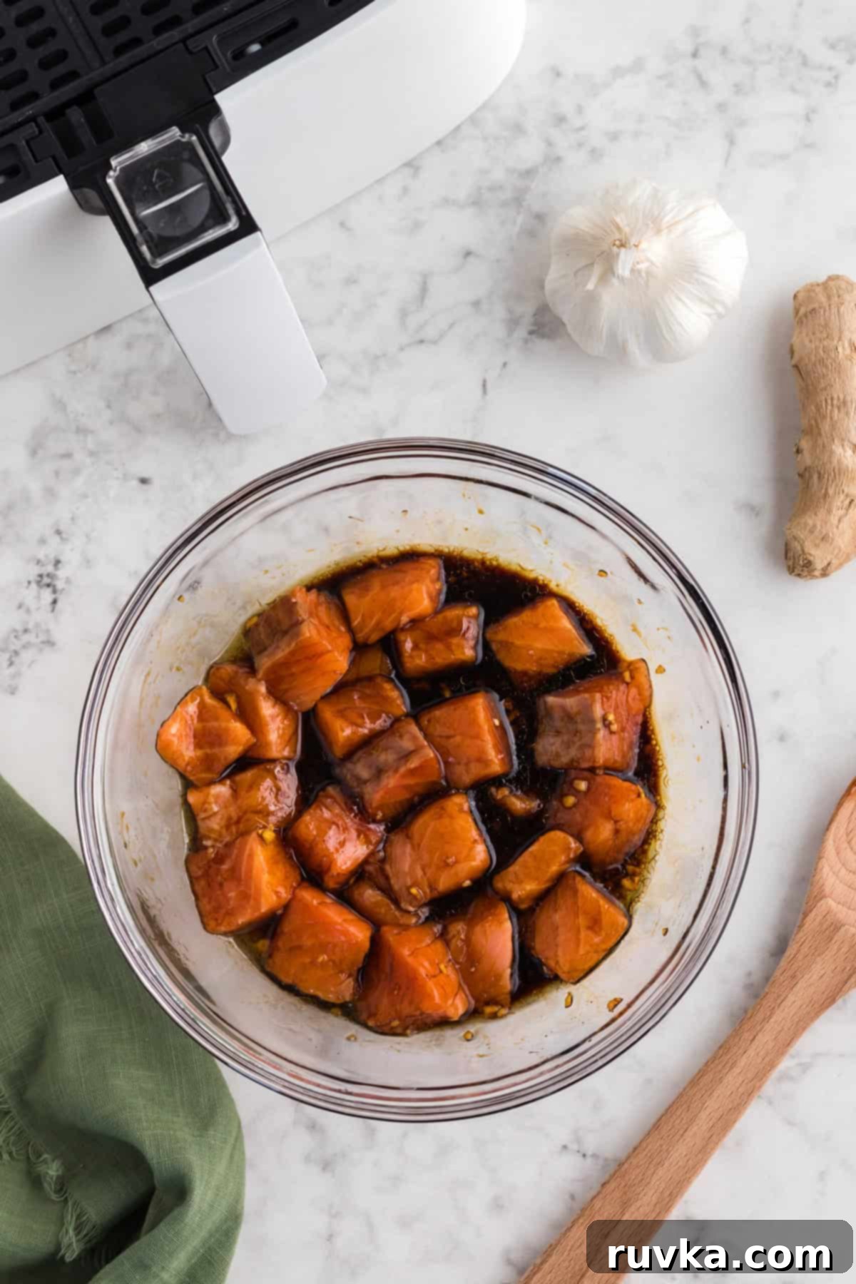 Step 3: Salmon bites soaking in the homemade teriyaki marinade in a bowl, covered with plastic wrap and refrigerated.