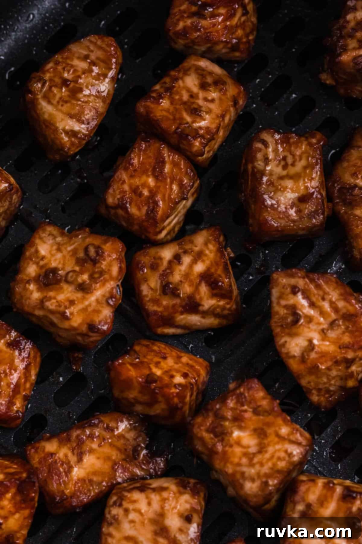 Step 6: Perfectly cooked Air Fryer Teriyaki Salmon Bites plated and garnished with sesame seeds and fresh green onions, ready to be served.